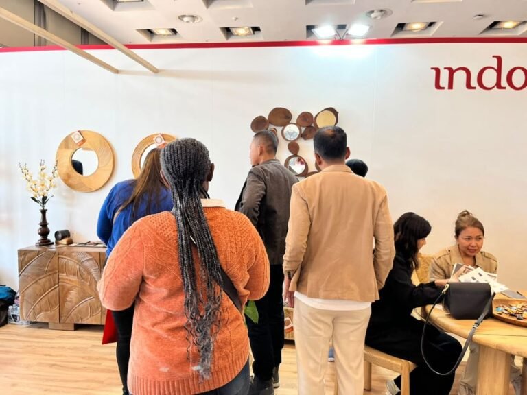 Visitors gathering at the Indonesia Pavilion with teak furniture and wooden mirrors on display