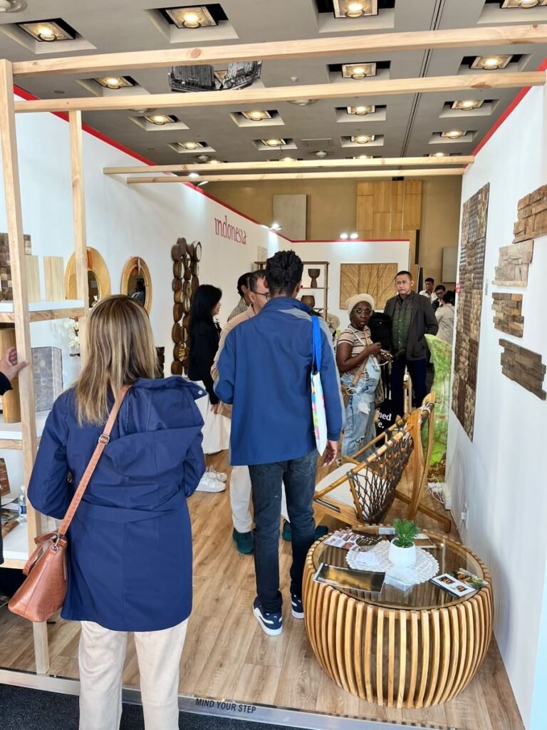 Visitors entering the Indonesia Pavilion booth with reclaimed teak wall cladding samples on the wall